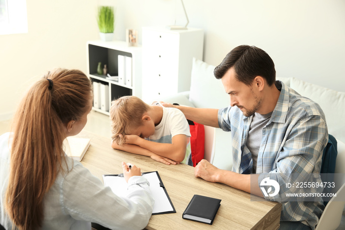 Young man and his son meeting with headmistress at school