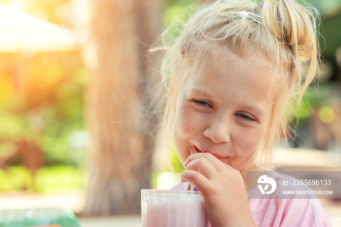 Adorable cute preschooler caucasian blond girl portrait sipping fresh tasty strawberry milkshake coc