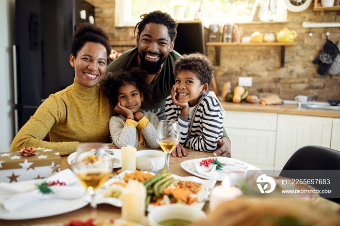 在餐厅吃圣诞午餐时快乐的黑人家庭的画像。