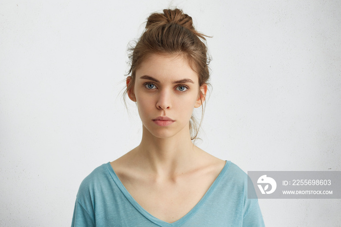 年轻欧洲女性的肖像，拥有健康干净的皮肤和蓝色的眼睛，穿着休闲上衣，看起来很性感