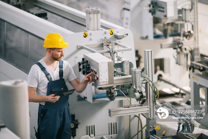 Man with helmet working in factory.