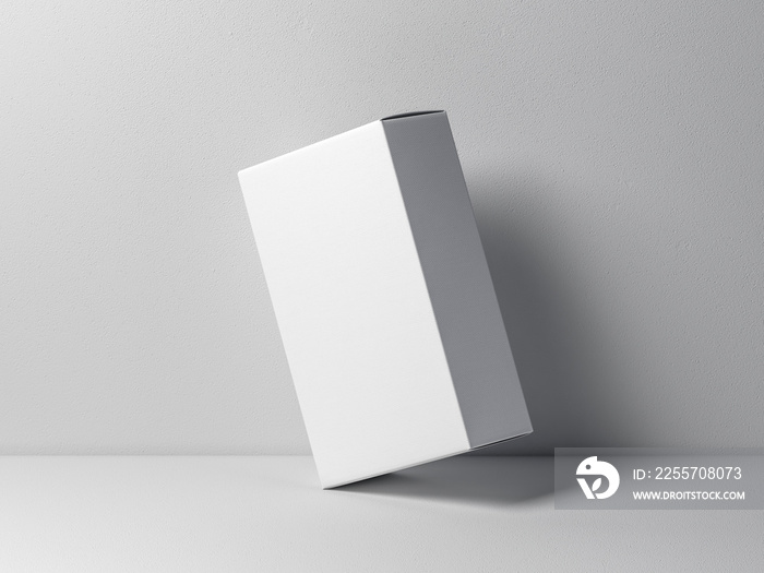 White cardboard box mockup leaning against a white wall