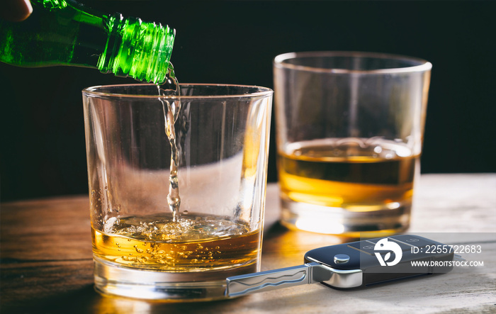 Drinking and driving concept. Car key and alcohol glass on wooden background. 3d illustration.