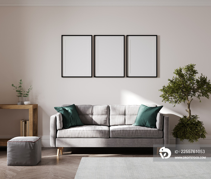 客厅内部米色墙上的空海报框架，配有现代家具和植物，灰色沙发