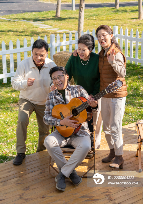 一群中老年人在房车露营地弹吉他唱歌