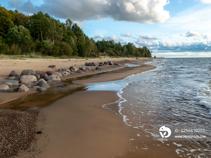 seascape image of the sea with cloudy sky before sunset,  stones and  of light before sunset, beautiful sunny day and quiet sea. baltic sea, Tuja beatch, Latvia