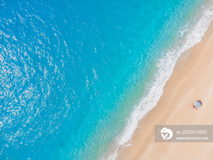 A background or texture of a beach with a lonely sun umbrella and turquoise sea