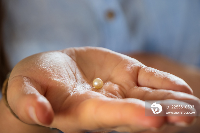 close up view to little pearl in hand on pearls farm in UAE