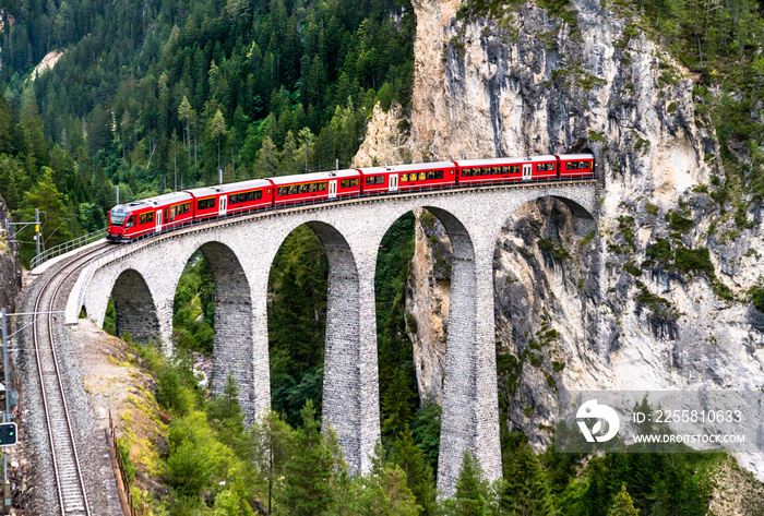 Passenger train crossing the Landwasser Viaduct in Switzerland