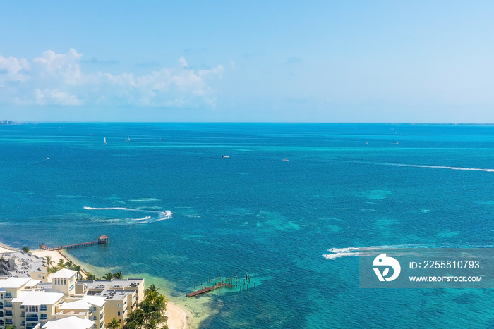 Aerial view of nautical vessel or yachts sailing on beautiful blue sea water surface with pier and hotel buildings at the coast