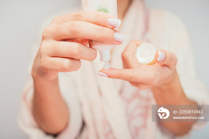 girl uses cream after bath. girl in a bathrobe hand cream