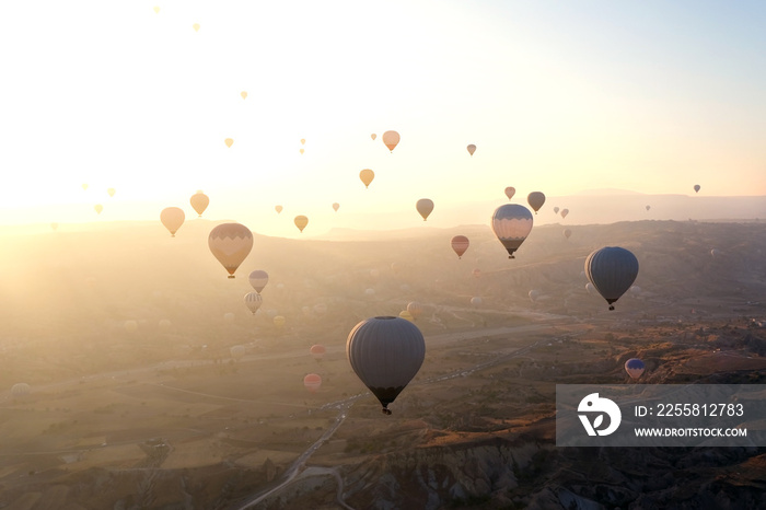 Hot air balloons above high mountain at sunrise or sunset