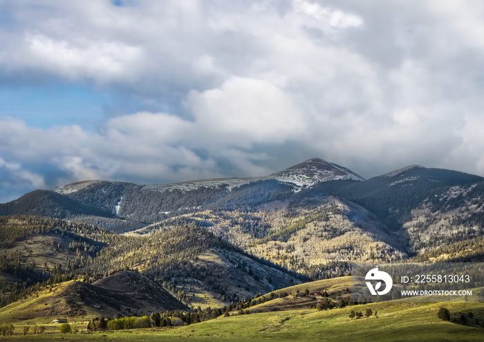 Sangre de Cristo Mountains east of Taos New Mexico with two houses in distance and snowy peak in background