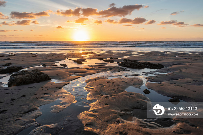 Stunning Summer sunset landscape image of Widemouth Bay in Devon England with golden hour light on beach