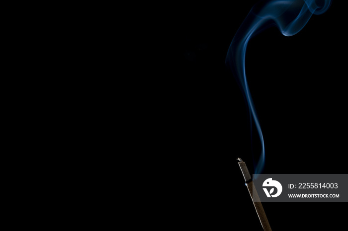 Incense stick or joss stick with smoke on black background