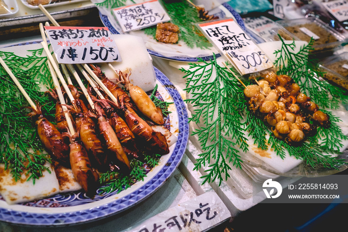 Cooked little squids and other seafood on skewers at Nishiki Market in Kyoto, Japan