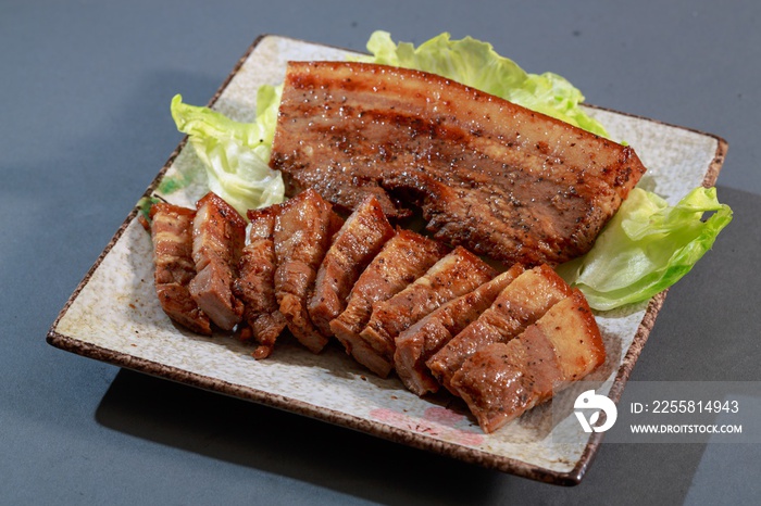 The plate of Hakka dishes pepper bacon with lettuce on grey back