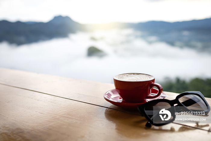 Morning red coffee cup with mountain view and mystic fog. with Sunglasses.