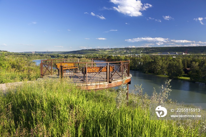 Observation Platform at East Bowmont Urban Recreation Park above Bow River with Green Prairie Grass and Distant Calgary, Alberta City Skyline