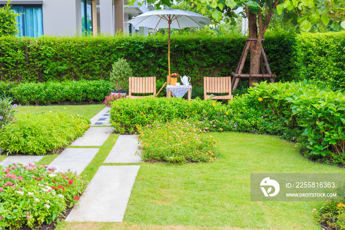 a beautiful wooden table set and big umbrella in the garden at afternoon.