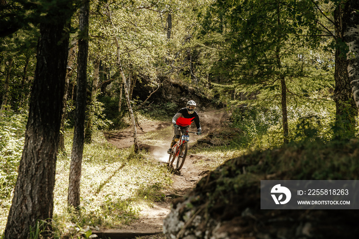 downhill competition race rider riding on forest trail