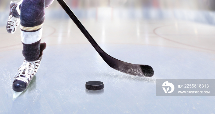 Close up of ice hockey player with stick on ice rink controlling puck