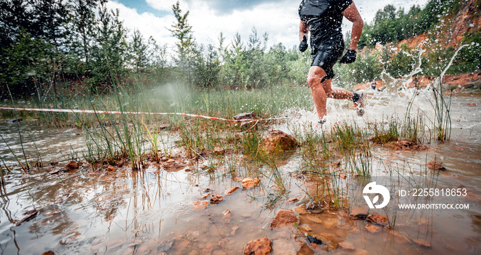 Cross country trail runner moving through water on rural road