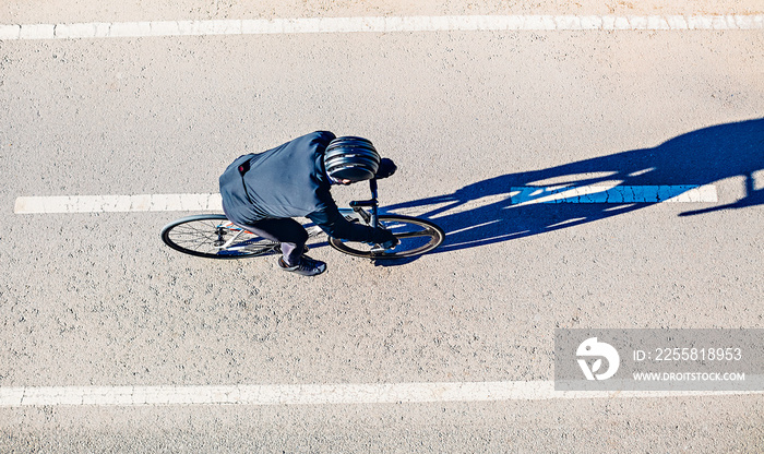 Top view of a man riding a bicycle. Early morning.