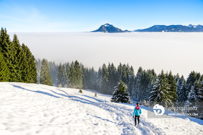 Sport, fitness inspiration and motivation. Young happy woman cross country running in mountains landscape on snow. Bavaria, Germany.