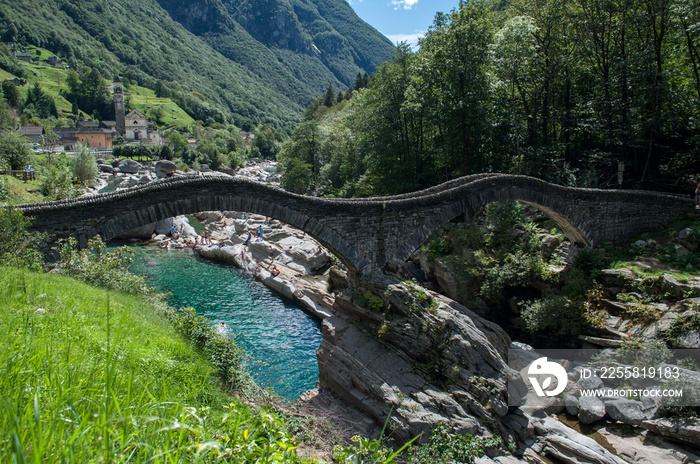 Old stone bridge over the river in the Verzasca valley in Switzerland. The bridge for hikers is an important monument.