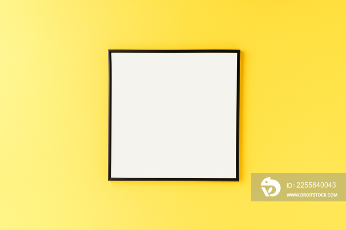 Mockup of empty picture frame on yellow background with copyspace