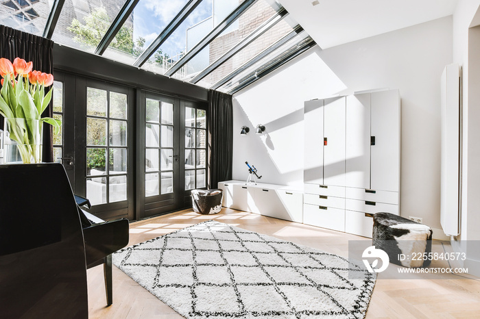 Interior of modern room illuminated with sunlight from ceiling window and door in modern house