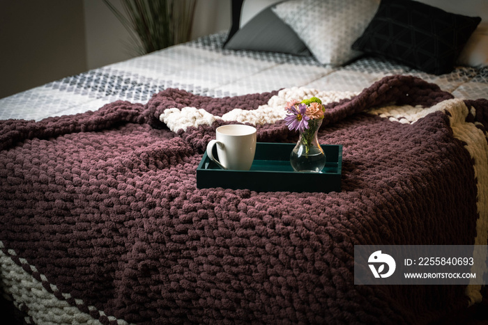 Home interior of cozy bedroom in modern design with pillows and soft custom made chunky blanket