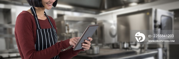Composite image of waitress using digital tablet against white