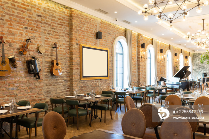 Interior of a modern hotel restaurant with old instruments hanging on the brick wall as a decoration