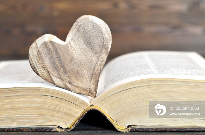 Heart shaped ornament and an old book. Creative love concept