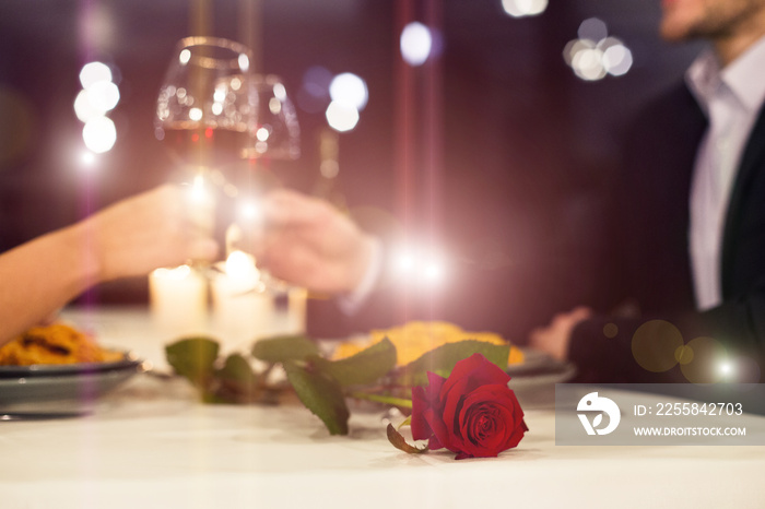 Romantic couple toasting with red wine during candlelight dinner