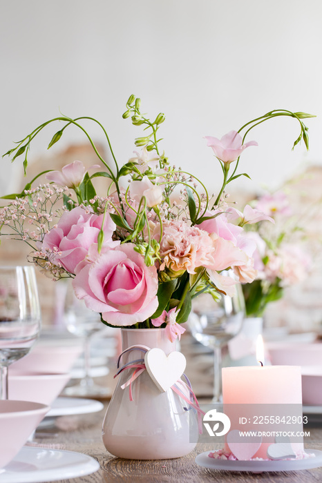 Tischdekoration für eine Hochzeit mit rosafarbenen Blumen