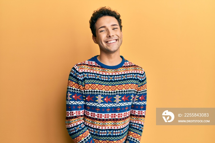 Young handsome man wearing casual winter sweater looking positive and happy standing and smiling wit