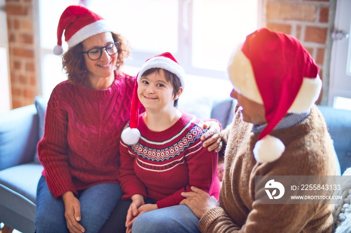 Beautiful family smiling happy and confident. Sitting on the sofa with smile on face wearing santa c