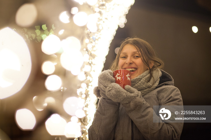 woman holding mug with mulled wine at christmas market