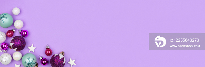 Modern pastel Christmas bauble corner border banner over a light purple background with copy space