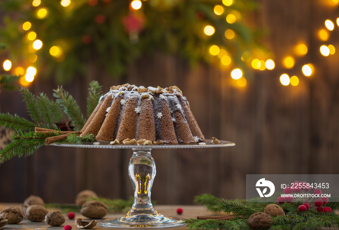 Christmas cake ahd fir branch  on dark wooden background