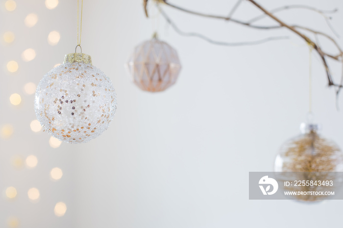 Christmas balls on golden branch in white interior