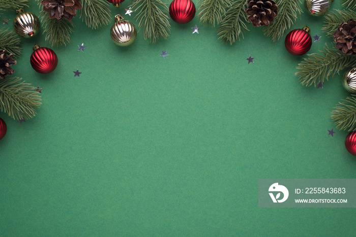 Top view photo of red and silver christmas tree balls on pine branches with cones and stars confetti