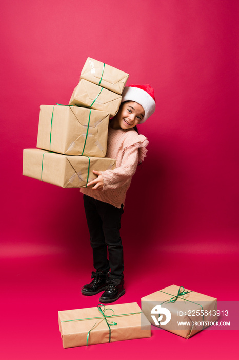 Cheerful little girl with a lot of christmas presents