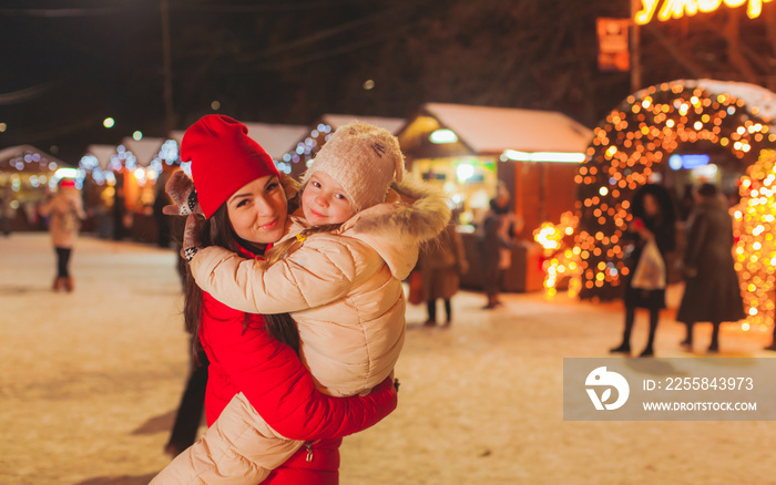 Happy mother and daughter at Christmas fair