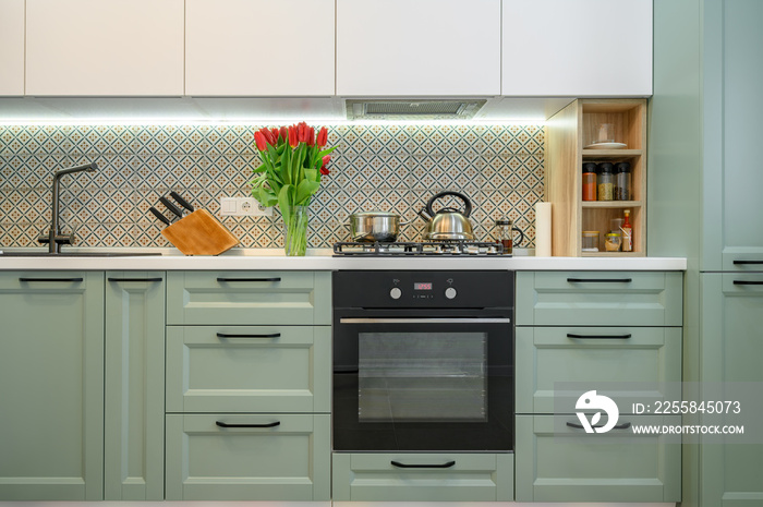 Modern green-teal kitchen interior, furniture front view