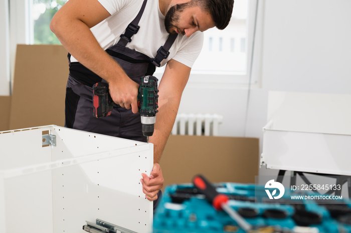 professional worker assembling cabinet indoor