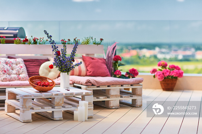 cute, cozy pallet furniture with colorful pillows at summer patio, lounge outdoor space